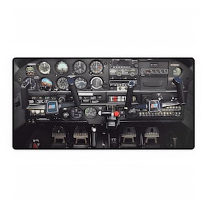 May include: A black and grey aircraft cockpit with a variety of gauges and controls. The cockpit is lit up and the gauges are visible. The controls are in the centre of the image.
