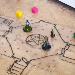 Könnte beinhalten: Ein Tisch-Rollenspiel-Setup mit einer Karte, Miniaturfiguren, Würfeln und anderen Spielsteinen. Die Karte ist beige mit schwarzen Linien und Kreuzen. Miniaturfiguren sind ein Zombie, eine Zauberin und ein Goblin. Würfel sind gelb und rosa.