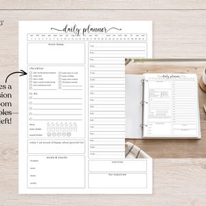 May include: A white daily planner page with black text featuring a monthly calendar, a brain dump section, a checklist, a to-do list, a schedule from 7 am to 11 pm, a mood tracker, water intake icons, and sections for meals, snacks, and exercise.