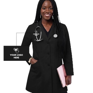 May include: A black medical lab coat with a stethoscope and the text "YOUR LOGO HERE". The coat has a V-neck, three buttons, and pockets. A pink laptop is held in the right hand.