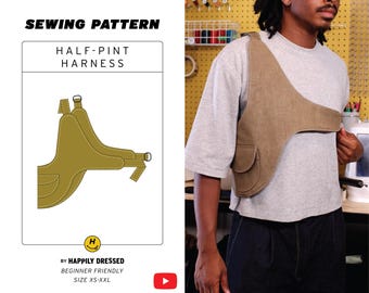 May include: A tan-colored Half-Pint Harness, a sewing pattern, is displayed on a white background. The pattern includes a diagram of the harness design. The text "SEWING PATTERN" and "HALF-PINT HARNESS" are visible. The text "BY HAPPILY DRESSED" is also visible.