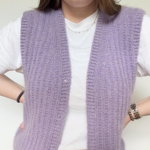 May include: A lavender knitted vest with a V-neck and ribbed texture.