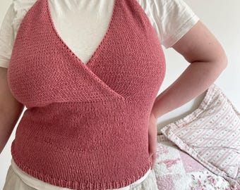 May include: A pink knitted halter top with a criss-cross front.