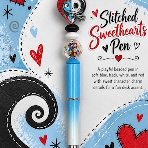 May include: A beaded pen featuring a heart-shaped charm with split character faces, a clear bead with a character graphic, and alternating black, white, and blue beads. The pen body is light blue and white with a silver tip and text Stitched Sweethearts Pen.