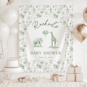 May include: A rectangular fabric backdrop featuring a repeating sage green pattern of elephants, giraffes, and trees. The center displays the text "Rachael's BABY SHOWER June 20, 2025" with illustrations of an elephant, a giraffe, and balloons.