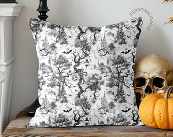 May include: A square throw pillow featuring a black and white repeating pattern of haunted castles, gnarled trees, flying bats, and jack-o'-lanterns. The text "PERSONALIZABLE" is printed in a small arc in the upper right corner of the design.