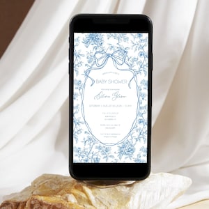 May include: A black smartphone shows a baby shower invitation. The invitation has a blue floral pattern with a bow and an oval frame. The text on the invitation reads "Baby Shower" and includes event details.