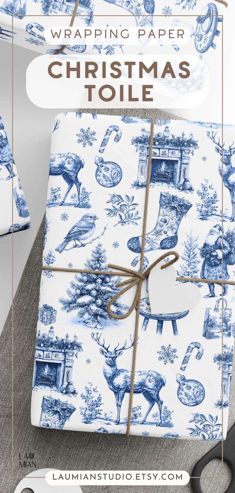 Puede incluir: Papel de regalo blanco con un patr&oacute;n toile azul de motivos navide&ntilde;os que incluyen ciervos, calcetines, chimeneas, p&aacute;jaros, bastones de caramelo y adornos. El papel est&aacute; atado con cuerda marr&oacute;n y tiene una etiqueta blanca en forma de coraz&oacute;n.