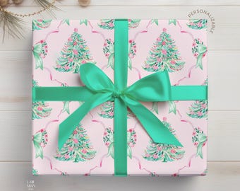 May include: A square gift box wrapped in light pink paper featuring a repeating pattern of watercolor-style Christmas trees and mint green bows, tied with a vibrant mint green satin ribbon. The text PERSONALIZABLE is printed in the top right corner.