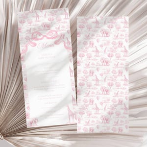 Op de afbeelding: Twee roze en witte babyshower menu's. Eén menu bevat de tekst "Menu" en "Ameliy's Baby Shower". Het andere menu heeft een herhalend patroon van giraffen, olifanten, bomen en luchtballonnen. De menu's staan op een witte achtergrond.