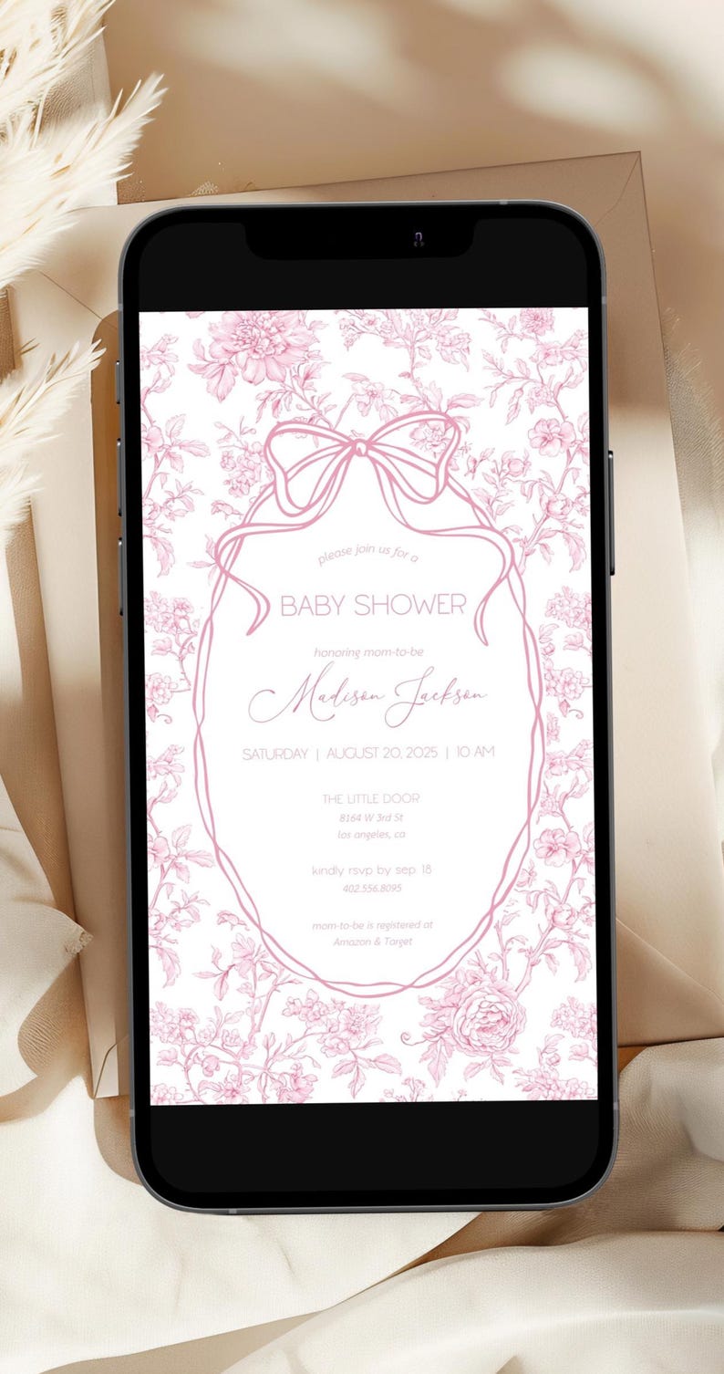 May include: A baby shower invitation displayed on a smartphone. The invitation features a pink floral design with a bow and text that reads "Baby Shower" and details for Madison Jackson's shower on August 20, 2025.