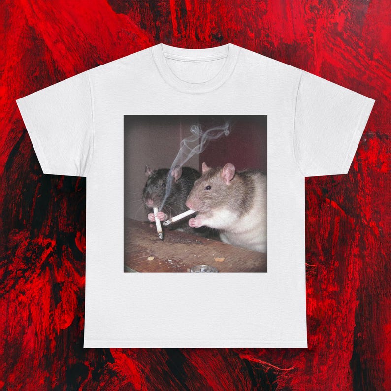 Puede incluir: Camiseta blanca con un gr&aacute;fico de dos ratas fumando cigarrillos. Una rata es negra y la otra marr&oacute;n y blanca. El humo se eleva de los cigarrillos. La imagen est&aacute; sobre un fondo oscuro.