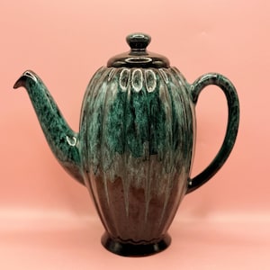 May include: A set of three ceramic mugs with a speckled, matte finish. Each mug features a different color: light blue, cream, and gray. The mugs have a simple, modern design with a rounded shape and a comfortable handle.