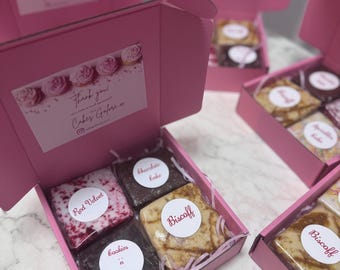 May include: Pink gift boxes containing individually wrapped cakes and brownies, such as Red Velvet, Chocolate Cake, Biscoff, and Cookies 'n Cream. Each box has a label that says "Thank you! Cakes Galore xx".