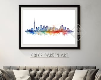 May include: A watercolor painting of the Toronto skyline with a colorful, abstract background. The painting is framed in a black frame and is hanging on a white wall above a gray couch.