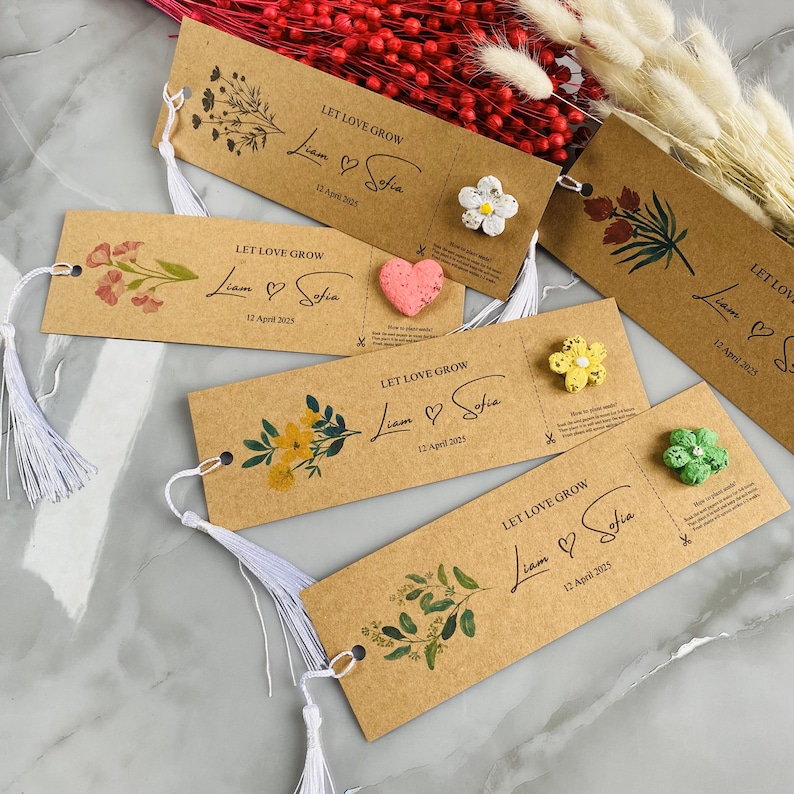 May include: Kraft paper bookmarks with floral designs and the text "LET LOVE GROW" along with names and a date. Each bookmark has a white tassel and a small decorative element, such as a flower or heart.