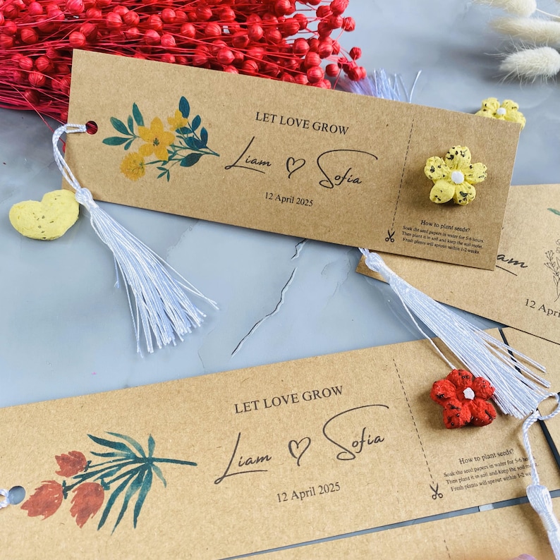 May include: Brown paper tags with the text "LET LOVE GROW", names, and the date "12 April 2025". Each tag has a floral design and a tassel. Some tags have small flower-shaped embellishments.