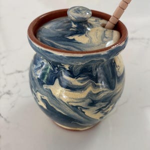 Tarro de miel de cerámica hecho a mano con cucharón de Red Wing Pottery en espirales azules.
