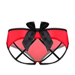 May include: Red and black lingerie with a large black bow in the centre and criss-cross straps.