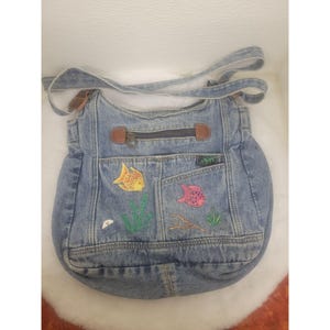 Bolso de hombro de mezclilla reciclada con bordado de peces de colores y detalles de piel sintética marrón