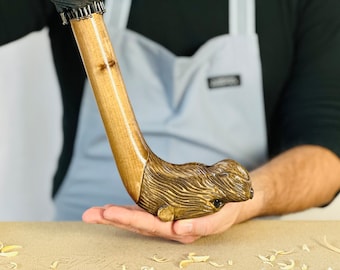 Puede incluir: Un bastón de madera con un mango tallado en forma de cabeza de animal. El mango está detallado con pelo y ojos. El bastón es marrón y tiene un acabado de madera natural.