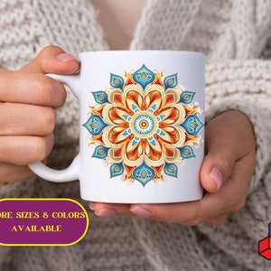 May include: White ceramic mug with a colorful mandala design. The mandala features blue, orange, and yellow colors. The text "MORE SIZES & COLORS AVAILABLE" is printed below the mug.