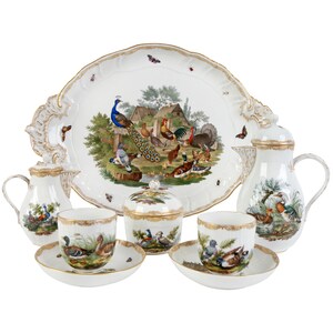 May include: A white porcelain tea set with a tray featuring a colorful scene of birds and a peacock. The set includes a teapot, creamer, sugar bowl, and two teacups and saucers.