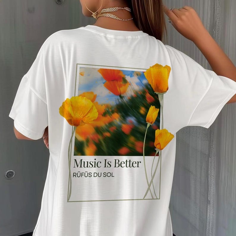 May include: White t-shirt with a graphic print of yellow flowers and the text "Music Is Better" and "R&Uuml;F&Uuml;S DU SOL" on the back.