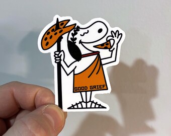 May include: A white sticker featuring a cartoon character in an orange toga holding a pizza slice and a pizza-topped staff. The text "GOOD GRIEF" is printed on the toga. The character is smiling and appears to be enjoying the pizza.