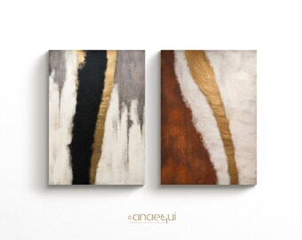 May include: Two abstract paintings with gold accents. The painting on the left has black, gray, and white paint. The painting on the right has brown, white, and gold paint.