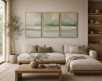Pode incluir: Uma sala de estar moderna com uma paleta de cores neutras. Um grande sofá seccional bege com almofadas está voltado para uma mesa de centro de madeira. Três pinturas abstratas emolduradas de paisagens estão penduradas acima do sofá. Uma árvore em vaso e prateleiras embutidas completam o espaço.