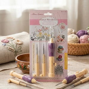 Puede incluir: Un juego de agujas de perforación de Mina Carin, con un mango morado y beige. El juego incluye múltiples agujas y accesorios, exhibidos sobre un fondo a rayas rosas y blancas. El embalaje incluye ilustraciones florales y el texto "Punch Needle Set".