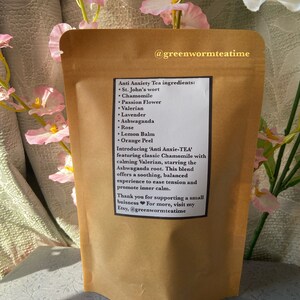 Puede incluir: Una bolsa de papel marr&oacute;n con una etiqueta que dice "Ingredientes del t&eacute; antiansiedad: Hierba de San Juan, manzanilla, flor de la pasi&oacute;n, valeriana, lavanda, ashwagandha, rosa, b&aacute;lsamo de lim&oacute;n, c&aacute;scara de naranja. Presentamos 'Anti Anxie-TEA' con manzanilla cl&aacute;sica y valeriana calmante, protagonizada por la ra&iacute;z de ashwagandha. Esta mezcla ofrece una experiencia relajante y equilibrada para aliviar la tensi&oacute;n y promover la calma interior. Gracias por apoyar un peque&ntilde;o negocio. Para m&aacute;s informaci&oacute;n, visita mi Etsy, @greenwormteatime"