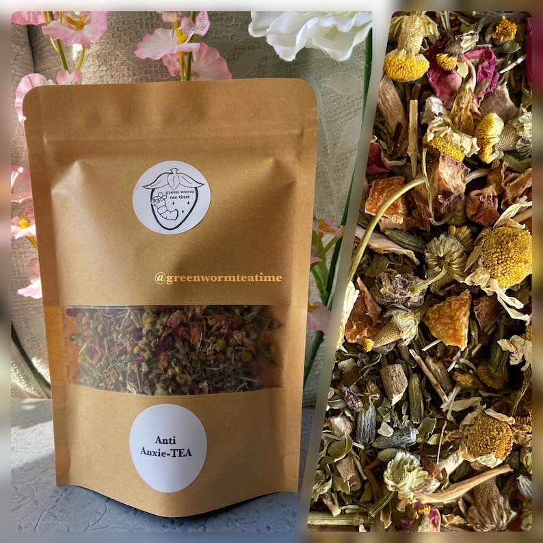 Puede incluir: Una bolsa de papel marr&oacute;n con una ventana transparente que muestra una mezcla de hierbas secas, flores y trozos de fruta. La bolsa tiene una etiqueta que dice "Anti Anxie-TEA" y un logotipo con una fresa y el texto "@greenwormteatime".