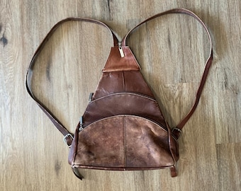 Zaino triangolare vintage anni '90 in pelle marrone con tracolla regolabile tramite cerniera e 3 o più tasche.
