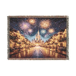 Könnte beinhalten: Gewebte Wurfadecke mit einer Nachtszene mit Feuerwerk über einem Schloss und einer Straße mit Gebäuden und Straßenlaternen. Die Decke hat einen Fransenrand und ein detailliertes, farbenfrohes Design.