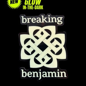 Könnte beinhalten: Ein im Dunkeln leuchtender Ansteckpin mit schwarzem Hintergrund und einem weißen, komplexen, vierblättrigen Knotendesign. Der Text "breaking" steht in Weiß über dem Knoten, "benjamin" darunter. Ein "NEW GLOW-IN-THE-DARK" Sternsymbol ist ebenfalls zu sehen.