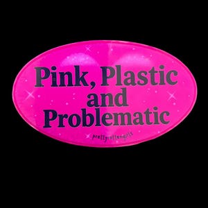 Peut inclure: Un autocollant ovale rose vif avec le texte "Pink, Plastic and Problematic" en lettres gris foncé. L'autocollant comprend également le texte "prettyrottengirls". Le fond est noir.