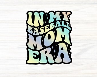 Op de afbeelding: Een sticker met de tekst "IN MY BASEBALL MOM ERA" in een retro lettertype. De tekst heeft een verloop van geel, blauw en groen, met een zwarte omlijning. Kleine sterren zijn verspreid rond de tekst.