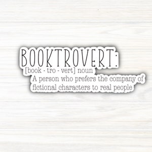 May include: A white sticker with black text that reads "BOOKTROVERT: [book-trovert] noun A person who prefers the company of fictional characters to real people."