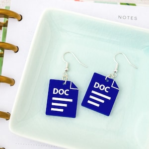 May include: A pair of novelty earrings featuring a blue DOC file design with white text and lines. The earrings hang from silver-colored fish hook ear wires. The earrings are displayed on a light blue square dish.