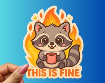 May include: A sticker featuring a cartoon raccoon with gray fur, large eyes, and a pink mug, sitting in front of orange flames. The text "THIS IS FINE" is below the raccoon in orange letters. The background is a gradient of blue.