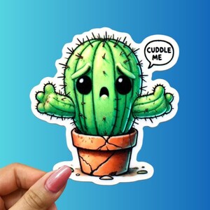 May include: A cartoon cactus with a sad face and the words "Cuddle Me" in a speech bubble. The cactus is green and has a cracked brown pot.