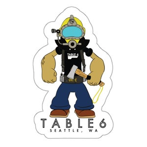 May include: A cartoon illustration of a diver wearing a yellow helmet and holding an axe. The diver is wearing a black shirt with the text "TABLE 6" on it. The text "TABLE 6 SEATTLE, WA" is at the bottom of the image.
