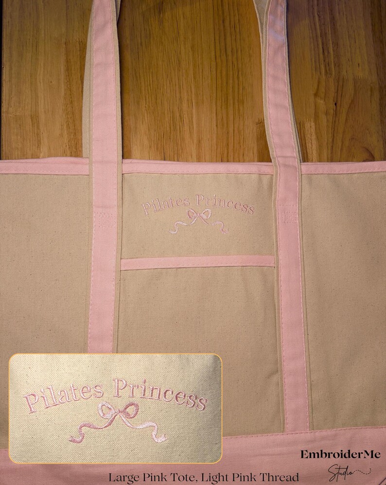 May include: A large pink canvas tote bag with pink straps and a pink embroidered design that says "Pilates Princess" with a pink ribbon bow.