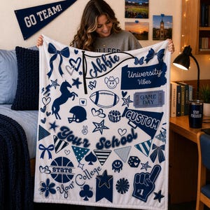 May include: A white fleece blanket with navy blue graphics, including a football, stars, and the words "University Vibes" and "Your School". The blanket has a personalized name banner.