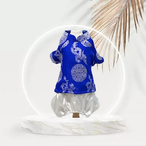 May include: A blue and white dog costume with a traditional Chinese design. The costume features a short-sleeved shirt with a mandarin collar and a pair of white trousers.