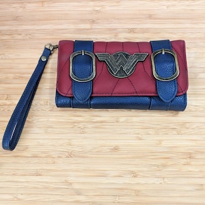 Cartera de mano triple con hebillas y logotipo de bronce antiguo de Wonder Woman