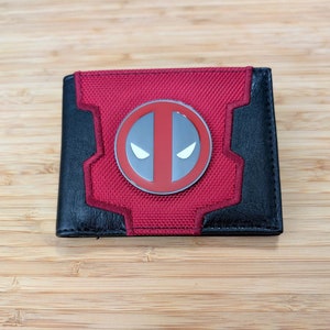 Cartera plegable con insignia de metal y logo de Dead Pool