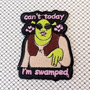 May include: Embroidered patch featuring a green cartoon character wearing sunglasses and a brown vest. The patch has the text "can't today" above the character and "I'm swamped" below, all in pink.